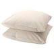 Two light beige, square-shaped pillows neatly stacked together. Made of 100% cotton, they have a smooth and simple design.