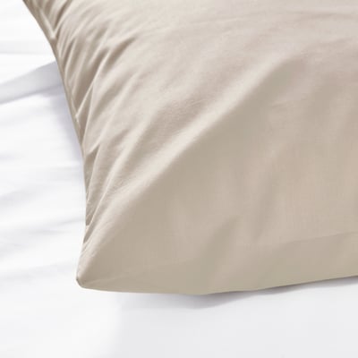 Two DVALA beige cotton pillowcases stacked, rectangular shape with simple design.