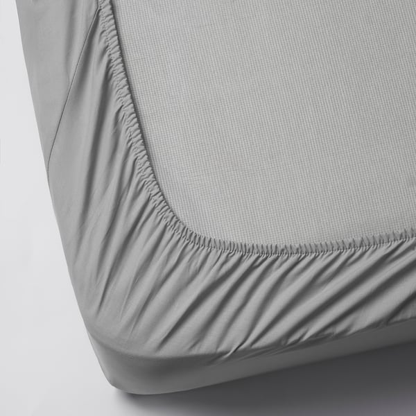 Grey fitted bedsheet with elastic edges, designed to fit mattresses up to 26 cm thick.