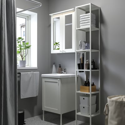 Modern bathroom with grey ENHET vanity, mirror, and shelving for towels.