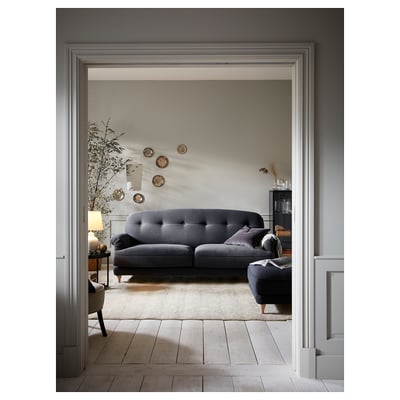 Modern living room with ESSEBODA grey sofa, wooden floors, and minimalist decor.