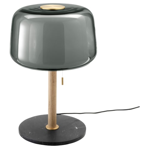 An EVEDAL table lamp with a dark green glass shade and a solid oak base featuring a marble base. Sleek, modern scandinavian design.