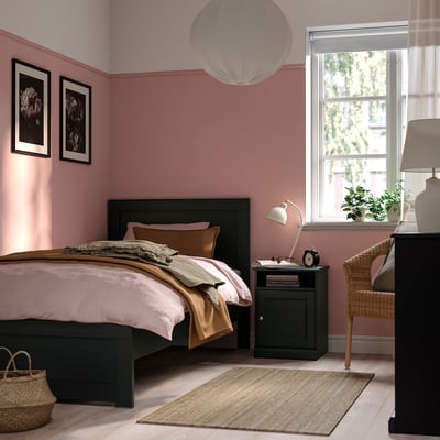 Cosy bedroom with FÅGELFJÄLLET bed, decorative panels, and window seat. Soft bedding, pink walls, and rug enhance warmth.