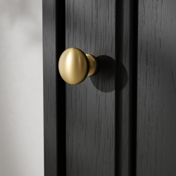 Gold doorknob on dark wooden door, reflecting light, showcasing sleek design and quality finish.