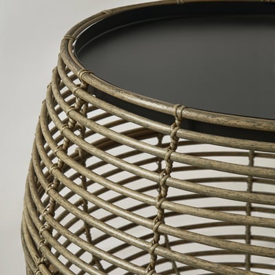 Round accessory table with woven pattern, light beige. Highlights intricate design and sturdy construction.