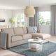 Modern living room with FINNALA beige sofa-bed, grey rug, and natural pendant light.