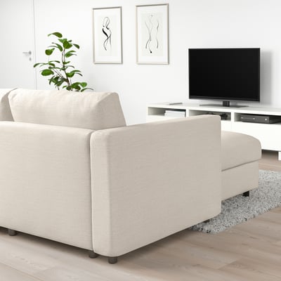FINNALA beige sectional sofa with minimalist design; fits well in spacious living room, under mounted tv, adjacent to potted plant.