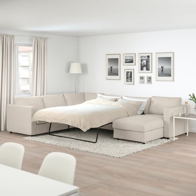 FINNALA sofa-bed in neutral tones on rug, with chaise, gallery photos, lamp, curtains.