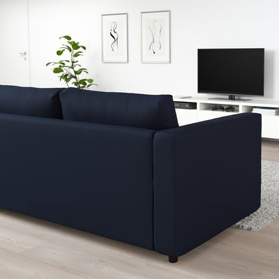 Modern living room with FINNALA dark blue sectional sofa, minimalist design, flat screen tv, and plant.