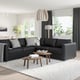 Modern living room with FINNALA grey sectional sofa, wooden coffee tables, patterned rug, hanging lamp, and large window with view.