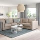 Modern living room with FINNALA beige sectional sofa, pendant lamp, glass coffee table, and large windows.