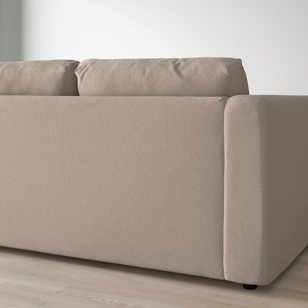 A beige FINNALA sectional sofa on light wood floor. Its stylish, modular, and offers comfortable seating.