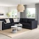 Modern living room with dark grey FINNALA sectional sofa, white cushions, and minimalist decor.