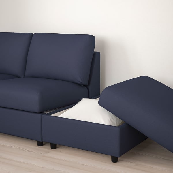 Dark blue sectional sofa with open storage compartment revealing a white cushion.