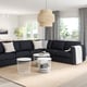 Dark grey l-shaped FINNALA sectional with plush cushions, coffee table, and pendant light in bright room with large windows.