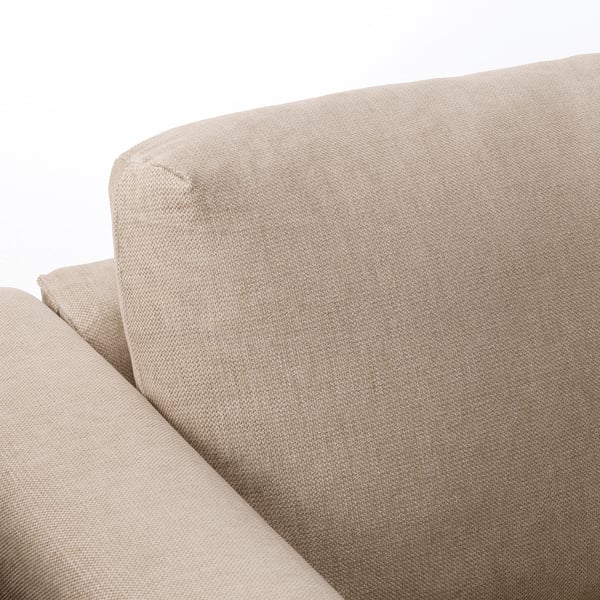 Close-up of FINNALA sofas plush, beige, rounded cushion. Soft fabric indicates comfort and quality.