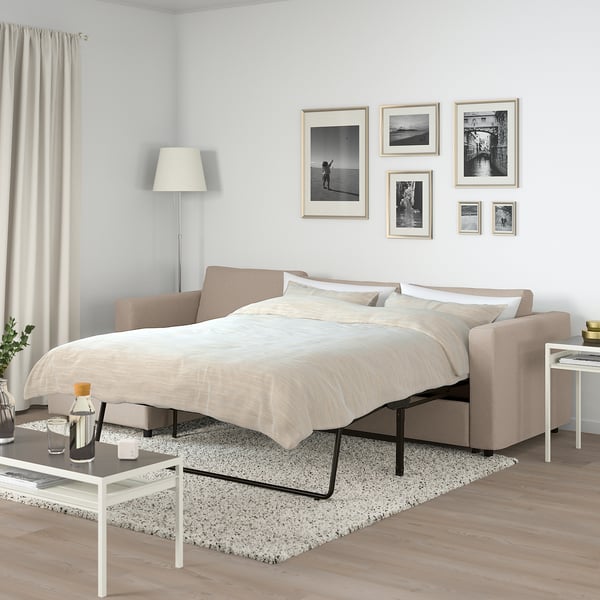 Minimalist bedroom FINNALA beige sofa-bed. Modern, cosy & functional with adjustable sections. Black & white artwork decorates light grey walls.