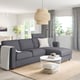FINNALA grey sectional sofa with white coffee table, nature-inspired decor, and large window.