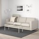 Modern living room with FINNALA beige sectional sofa, white coffee table, grey rug, black & white artwork, and white floor lamp.