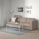 Modern living room with FINNALA sectional sofa in beige, grey rug, white coffee table, and wall art.