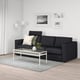 Modern living room with FINNALA charcoal sofa, white coffee table, grey rug, and wall art. Sofa is large, fitting well in spacious room.