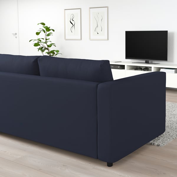 Dark blue FINNALA sectional sofa, modern, clean design, with tv and plant.