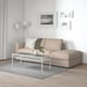 Minimalist living room with FINNALA beige sectional sofa, white coffee table, grey rug, and black & white wall art.