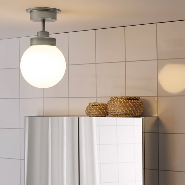 Pendant light above sink with glass shade & baskets.