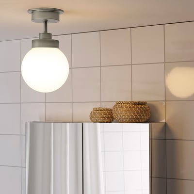 Pendant light above sink with glass shade & baskets.