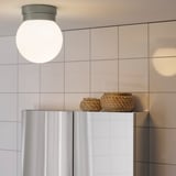 Modern bathroom ceiling light with globe bulb, metallic base, and soft light.