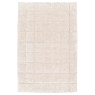 Experience the GEOLOG rug: soft, textured beige squares, exuding luxury and comfort.
