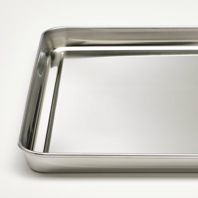 Stainless steel tray, shiny, rectangular, sturdy edges, empty, clean surface.