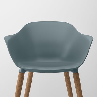 Modern chair with turquoise seat and armrests, supported by wooden legs, showcasing sleek design and comfort.