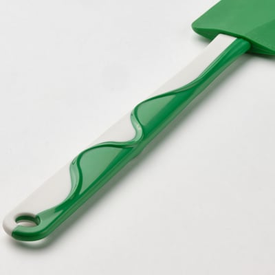 Green silicone spatula with white handle, designed for scraping bowls, non-stick surfaces, hanging hole at end.