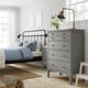 Modern bedroom with grey GULLABERG chest, metal bed, light wood floor, plant, lamp.