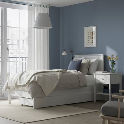 GULLABERG white wood bed frame. Modern classic with drawers, storage. Spacious room with chair, window, artwork.
