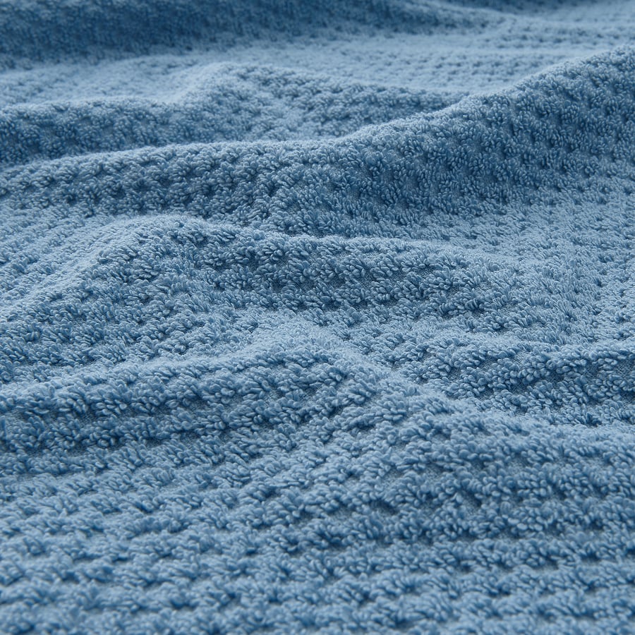 Close-up of soft, beige, textured cotton towel; feels thick, absorbent, and durable.