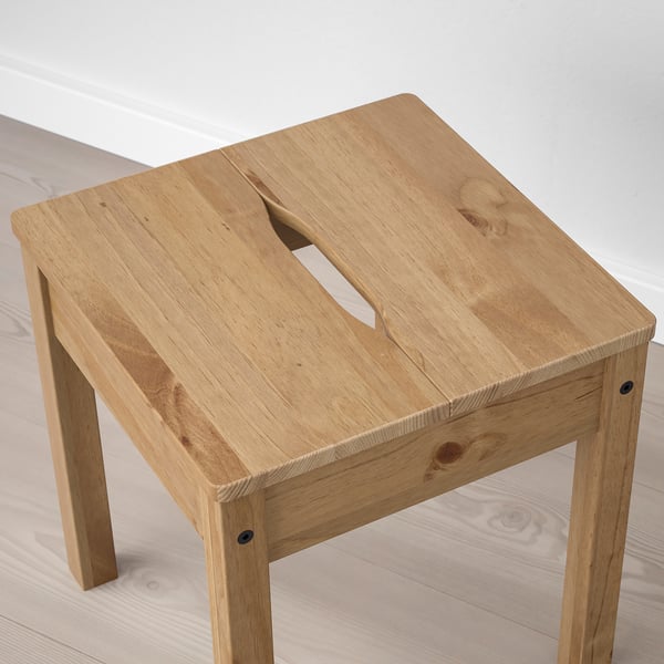 Handcrafted wooden stool with natural finish, sturdy design, and cut-out handle for easy movement.