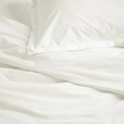 Crisp white bedding, neatly arranged. Soft cotton fabric, clean and inviting.