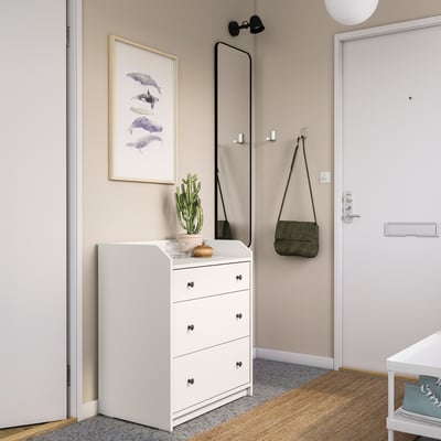 Modern entryway with white HAUGA chest, green cactus, framed art, full-length mirror, hanging bag, and natural light.