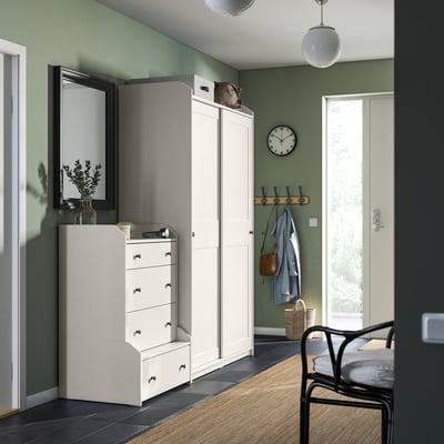 Modern room with HAUGA furniture: tall white wardrobe and chest of drawers for storage.