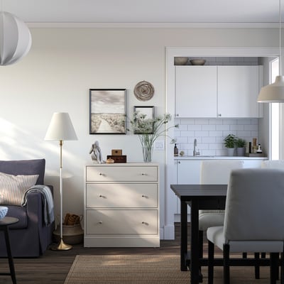 Modern living room with white HAVSTA chest of drawers, grey couches, and nature print.