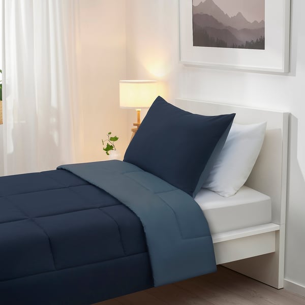 Navy blue bed set with soft brushed surface, white sham, mountain art, lamp, sheer curtains.