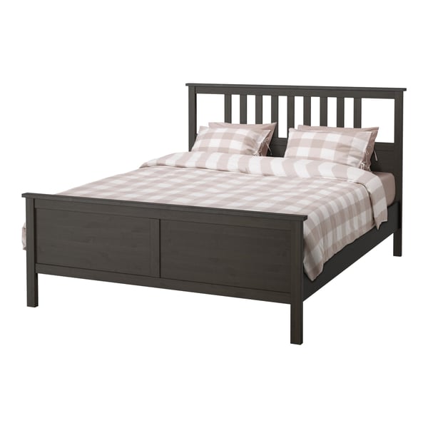 Black HEMNES bed with chequered bedding, solid wood construction, high headboard, clean rectangular design.