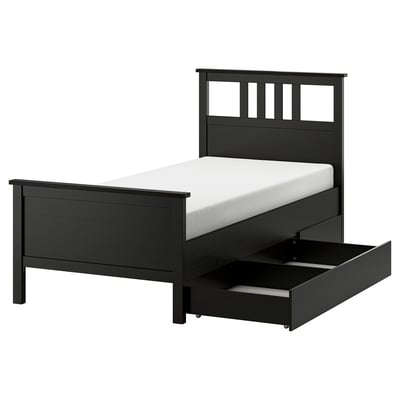 A black HEMNES bed frame with drawers and a white mattress. Its made of solid wood.