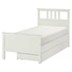 A white HEMNES bed with wooden drawers in a clean, modern design. Its a twin-size bed featuring solid pine construction and drawers for storage.