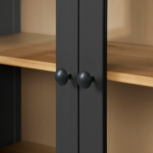 Close-up of dark wooden cabinet with round knobs, showcasing smooth finish and sturdy build.