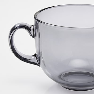 A translucent grey glass mug with a sturdy handle, showcasing sleek design and good quality.
