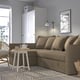 Cosy living room with HOLMSUND convertible sofa, side table, chair, rug, lamp, and wall art.