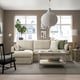 Modern living room with HYLTARP sofa, city view, pendant lamp, and tea on coffee table.